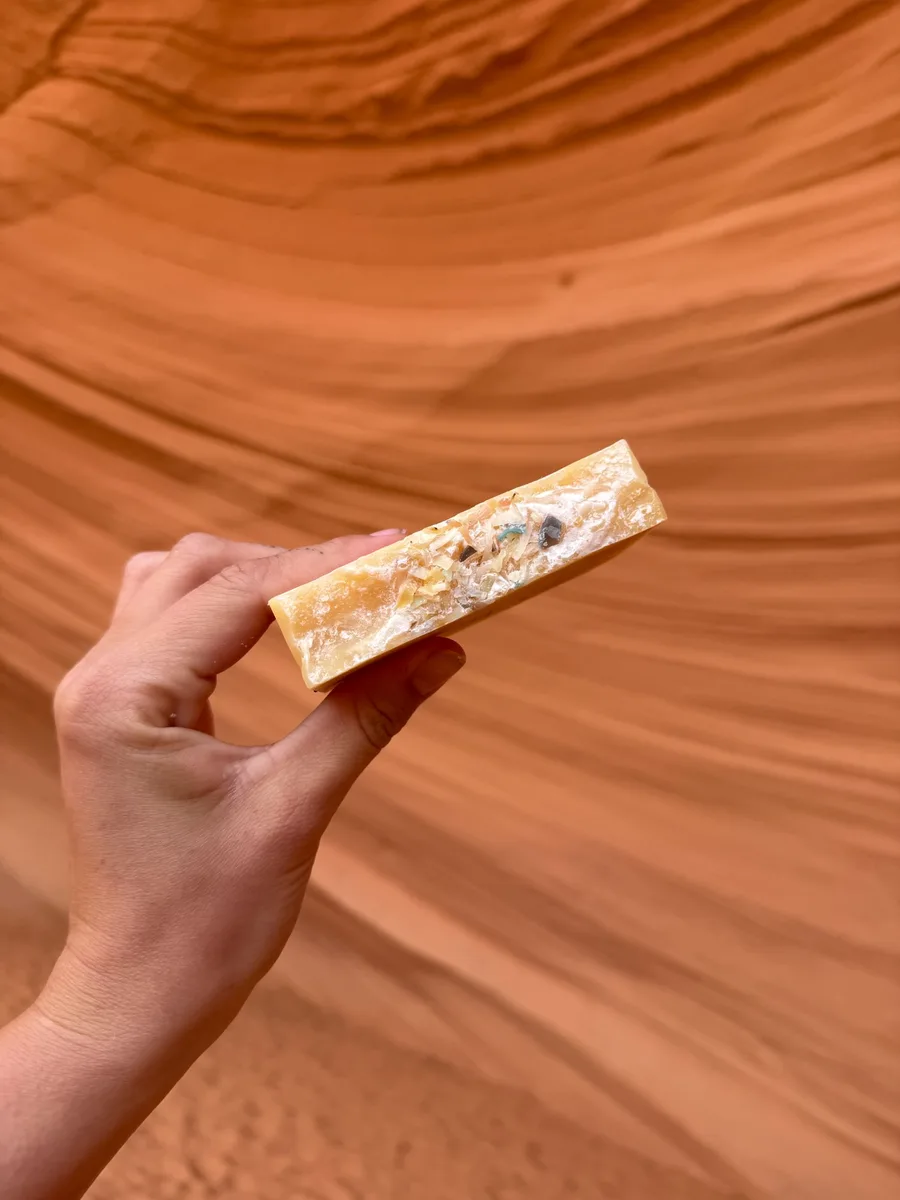 Handmade bar soap — honey gold with embedded botanicals, canyon backdrop
